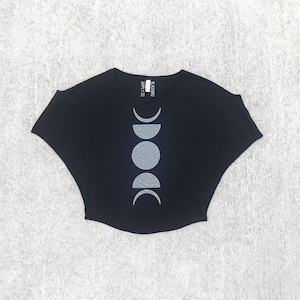 May include: Black short-sleeved t-shirt with a white moon phases design. The shirt has a relaxed fit and a slightly cropped hem. The text "BLACK MOON SUPPLY CO." is printed on the back of the neck.