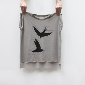 Bird Lover Shirt for Women. Two Chimney Swifts printed in black water based ink onto flowy loose fit muscle tees in beige. Features a crew neck, rolled cuffs, and a hi-low hem.