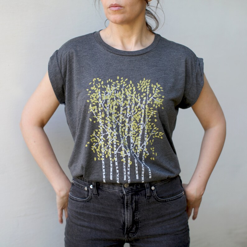 Może przedstawiać: Szary t-shirt z nadrukiem graficznym przedstawiającym grupę brz&oacute;z z ż&oacute;łtymi liśćmi.