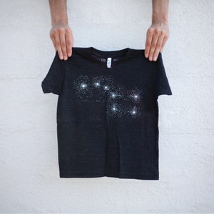 May include: A kid's heather black t-shirt with a stylized screen-print of the Big Dipper constellation.