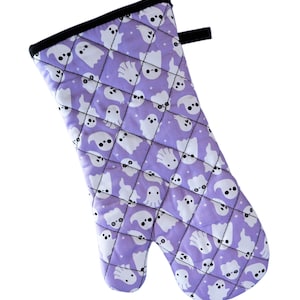 Peut inclure: Manique de cuisine violette avec un motif matelassé et un motif de fantôme blanc.