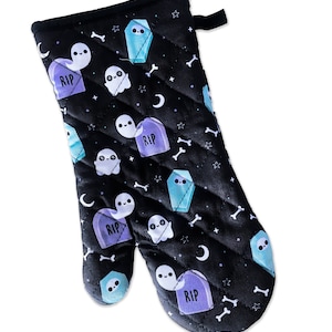 May include: Black oven mitt with a quilted pattern featuring a repeating design of ghosts, tombstones, and bones. The tombstones have the text "RIP" on them.