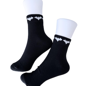 May include: A pair of black ankle socks with a white bat design on the cuff.
