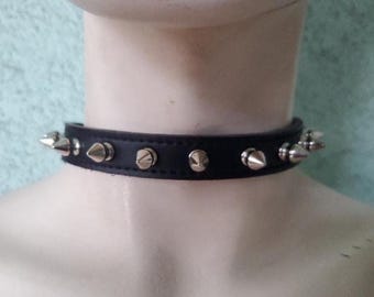 May include: A black leather choker with silver pyramid-shaped studs.