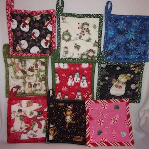 May include: A selection of eight quilted pot holders featuring festive designs. The patterns include snowmen, snowflakes, and candy canes in red, green, blue, and black. Each pot holder has a hanging loop and a contrasting border.