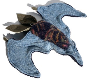 May include: A blue denim bat toy with a brown fabric wing and a colorful patterned head.