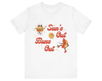May include: White t-shirt with a red and yellow graphic design featuring a cartoon burger, hot dog, and sun. The text reads "Sun's Out Buns Out".