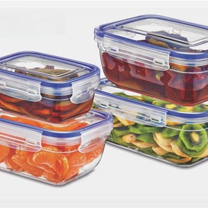 Puede incluir: Varios recipientes rectangulares transparentes para almacenar alimentos con detalles azules. Los recipientes están llenos de alimentos variados, como rodajas de naranja, kiwi en rodajas y un líquido rojo. Las tapas son transparentes.