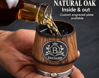 May include: A fire-charred natural oak cup with a metal base and an oval plate engraved with a crown, the letter B, and the name BERNARD. Amber liquid pours from a glass bottle into the cup. Text reads: FIRE-CHARRED NATURAL OAK Inside & out.
