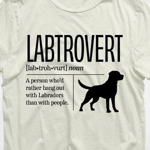 Peut inclure: Un t-shirt blanc avec du texte noir qui dit "LABTROVERT [lab-troh-vurt] nom Une personne qui préfère traîner avec des labradors plutôt qu'avec des gens." Une silhouette noire d'un labrador retriever est à droite du texte.