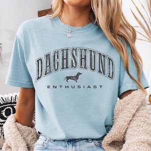 a woman wearing a blue shirt with a dachshund print