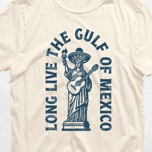 a white t - shirt with a statue of liberty holding a guitar