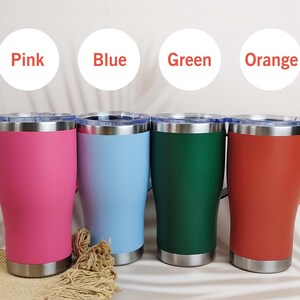 Puede incluir: Cuatro tazas de viaje de acero inoxidable en rosa, azul, verde y naranja. Cada taza tiene un asa y un borde y base plateados. Los colores est&aacute;n etiquetados encima de cada taza.