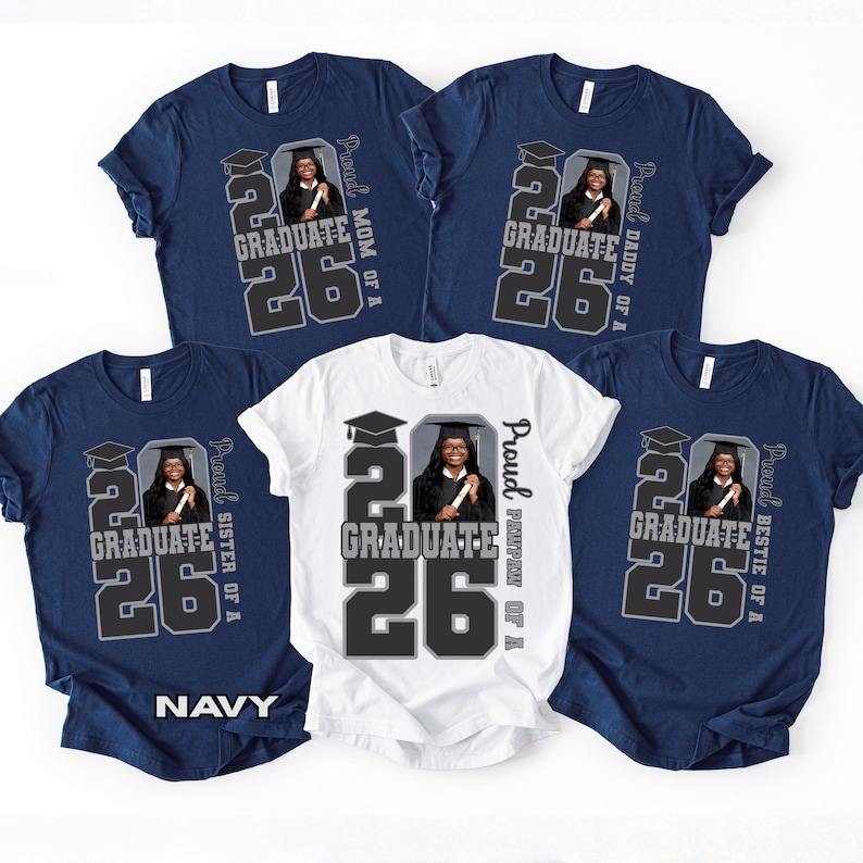 May include: Navy and white t-shirts with a graduation theme. Each shirt features a graphic with the text "GRADUATE 26" and a photo of a graduate. The shirts also include text such as "Mom of a", "Daddy of a", "Sister of a", and "Bestie of a".