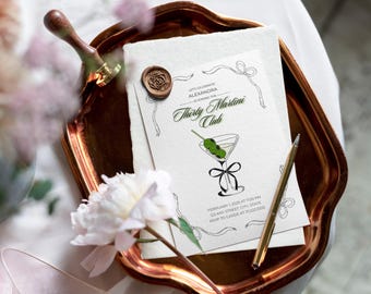 Könnte beinhalten: Eine weiße Einladungskarte mit schwarzem Text und einer Strichzeichnung eines Martini-Glases mit Oliven. Der Text lautet "Lasst uns Alexandra feiern, die dem Thirty Martini Club beitritt." Die Einladung enthält Datum, Uhrzeit, Adresse und RSVP-Informationen.