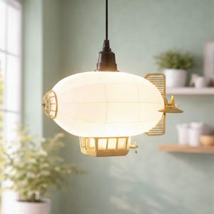 Könnte beinhalten: Eine einzigartige Hängeleuchte im Zeppelin-Design. Sie hat einen weißen, ovalen Lampenschirm mit Gittermuster und Messingfarbene Metalldetails, darunter ein Propeller und eine kleine käfigartige Struktur, die den Steampunk-Stil unterstreichen.