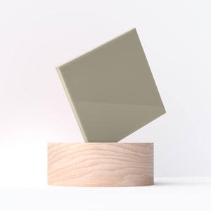 May include: A geometric composition featuring a light beige, angled square shape balanced on a cylindrical wooden base. The background is a clean, bright white, emphasizing the minimalist design and neutral color palette.