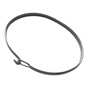 May include: A silver-colored metal bracelet with a simple, minimalist design. The bracelet has a circular shape with a hook clasp closure. The jewelry is shown against a white background.