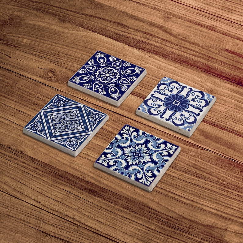 May include: Four blue and white ceramic coasters with intricate geometric patterns. The coasters are square and have a slightly raised edge.