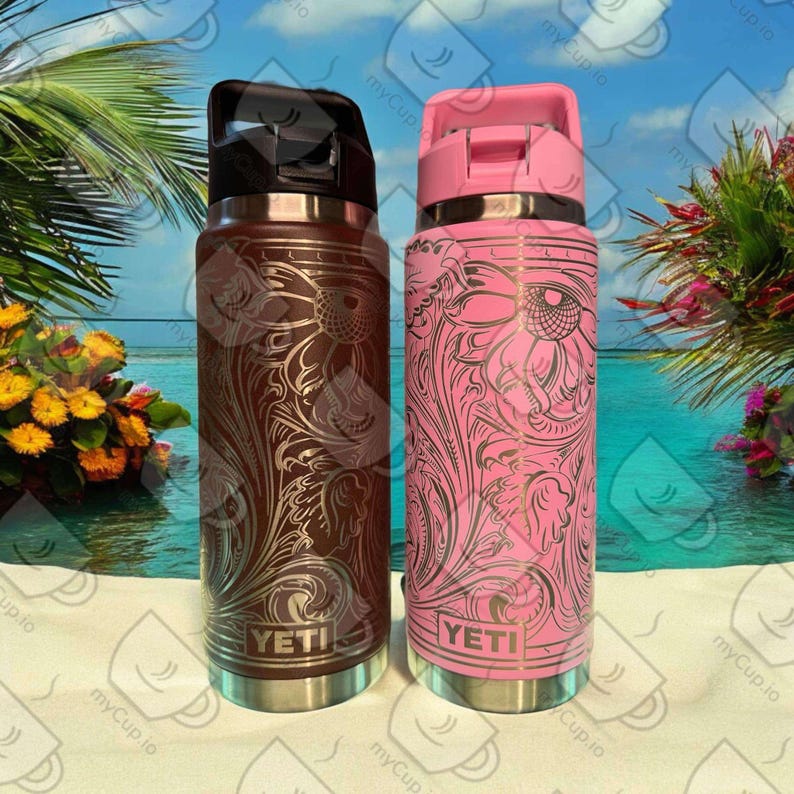 K&ouml;nnte beinhalten: Zwei YETI-Edelstahl-Wasserflaschen mit Blumenmuster. Die Flasche links ist braun mit goldenen Akzenten und die Flasche rechts ist rosa mit silbernen Akzenten.