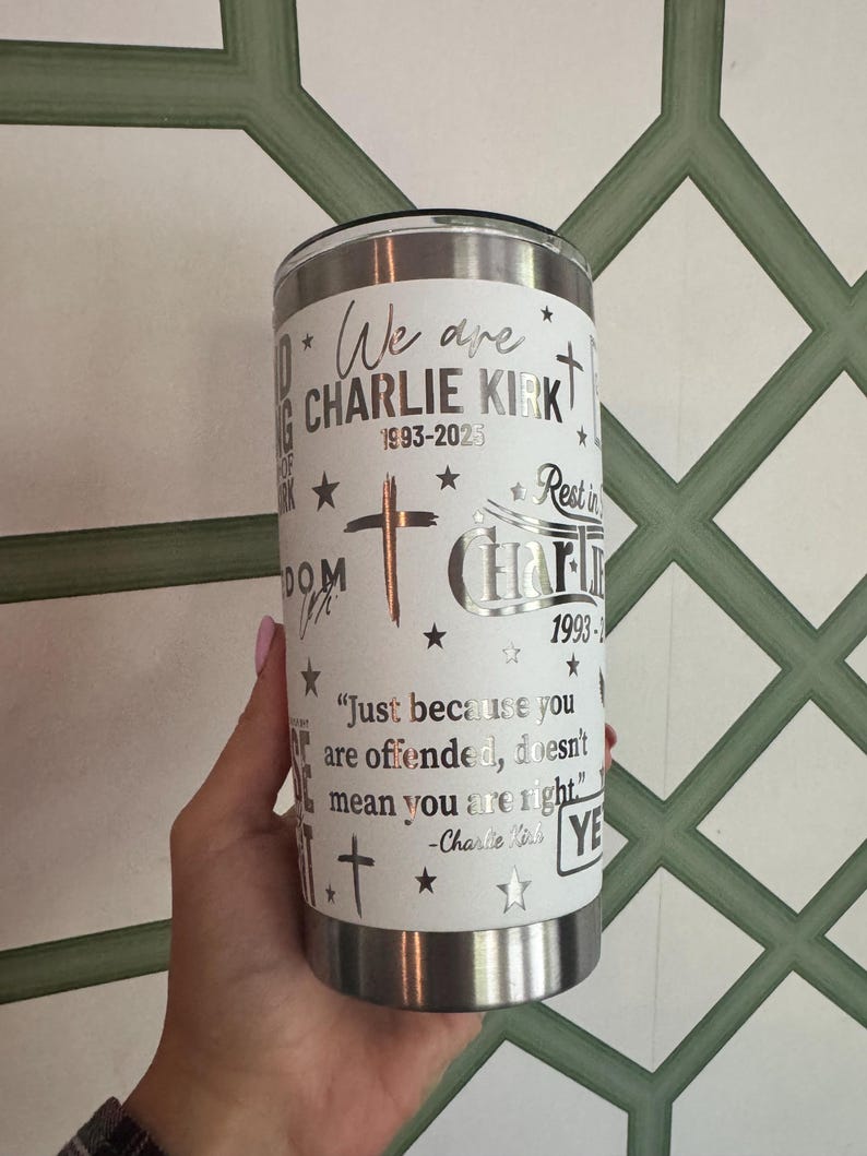Puede incluir: Un vaso de acero inoxidable blanco con borde y tapa plateados. El vaso presenta texto y gr&aacute;ficos, incluidas las palabras "We are CHARLIE KIRK 1993-2023", cruces y estrellas. Tambi&eacute;n incluye una cita de Charlie Kirk.