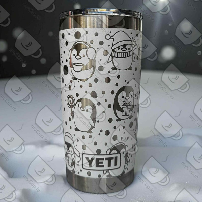May include: A stainless steel YETI tumbler with a white wrap featuring black penguin illustrations and polka dots. The penguins are depicted in various poses, some wearing hats and holding gifts. The YETI logo is visible.