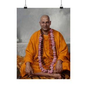 May include: A portrait print featuring a man in an orange robe, seated with legs crossed. He wears a garland of pink and orange flowers. The background is a soft, neutral gray.