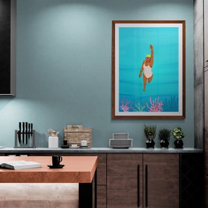 May include: A framed illustration of a person swimming underwater in a white and blue striped swimsuit. The background is a blue ocean with coral reefs. The frame is brown wood.