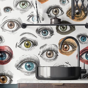 May include: A black bathroom sink with a white background featuring a repeating pattern of stylized eyes in various colors and shades. The sink is made of a smooth, reflective material and has a rounded shape.