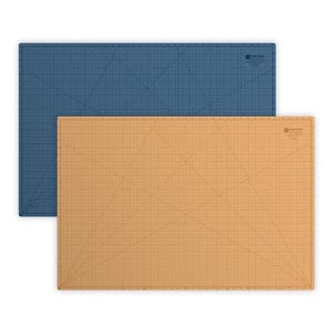 May include: Two rectangular self-healing cutting mats, one blue and one tan, featuring printed grid lines, angle markings, and measurement scales. Each mat displays the logo for 'Cose Dale' in the upper right corner with clear markings.
