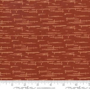 May include: A rust-colored fabric featuring a repeating pattern of horizontal, dashed, and textured light tan lines. A white measuring tape with black markings is visible at the bottom, showing a length of seven inches across the fabric edge.