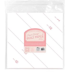 May include: A package of white quilt paper with pink diagonal lines and numbers. The label reads "Paper Strings Quilt Paper" and includes the dimensions 12x12 inches and 60 pieces.
