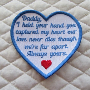 May include: White heart-shaped patch with blue edging and red heart at the bottom. The patch has embroidered text that reads: "Daddy, I held your hand you captured my heart our love never dies though we're far apart. Always yours."