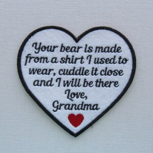 May include: White heart-shaped patch with black embroidered text that reads "Your bear is made from a shirt I used to wear, cuddle it close and I will be there Love, Grandma". A small red heart is embroidered in the bottom center of the patch.