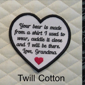 May include: White heart-shaped patch with black stitching and a red heart in the center. The patch has the text "Your bear is made from a shirt I used to wear, cuddle it close and I will be there. Love, Grandma." and the words "Twill Cotton" below the patch.