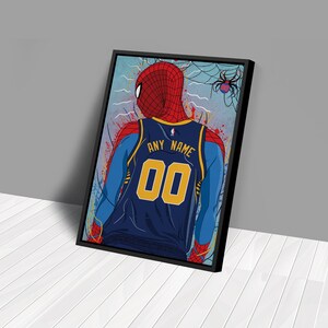Op de afbeelding: Een blauw en geel basketbaltenue met de tekst "ANY NAME" en het nummer "00" op de rug. Het tenue wordt gedragen door een cartoonfiguur met een rood en blauw Spider-Man-masker. De achtergrond is een blauw en wit abstract ontwerp met een spinnenweb.