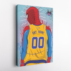 Op de afbeelding: Een geel en blauw basketbaltenue met een rood en blauw Spiderman-ontwerp. Het tenue heeft de tekst "ANY NAME" en het nummer "00" op de rug.
