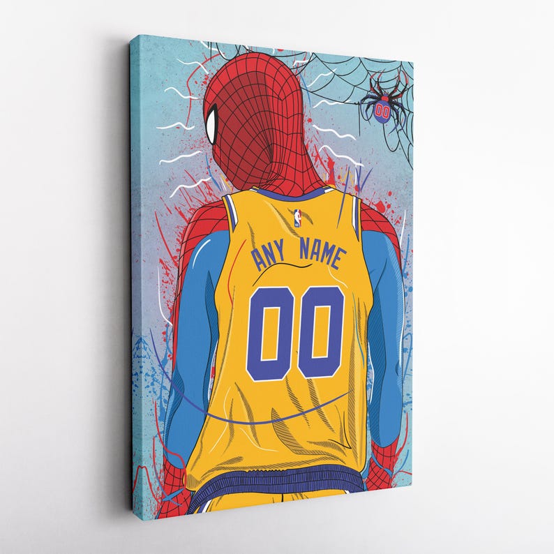 Op de afbeelding: Een geel en blauw basketbaltenue met een rood en blauw Spiderman-ontwerp. Het tenue heeft de tekst "ANY NAME" en het nummer "00" op de rug.