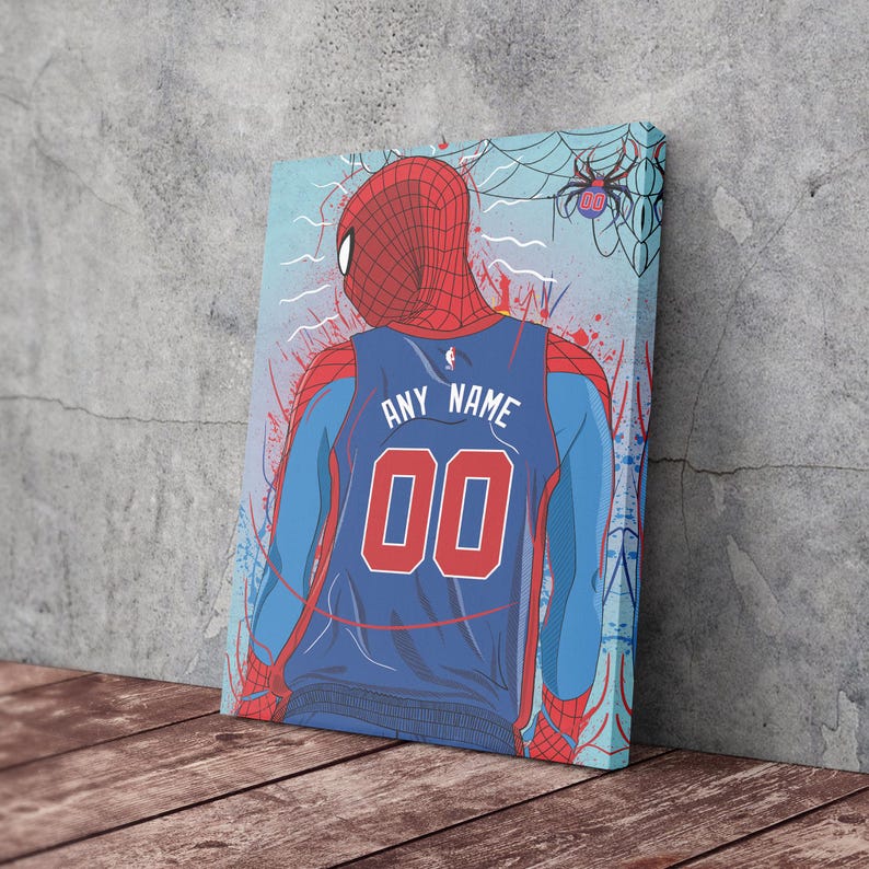 Op de afbeelding: Een digitale illustratie van Spider-Man die een blauw en rood basketbaltenue draagt met de naam "ANY NAME" en het nummer "00" op de rug. De achtergrond is een blauw en wit splatterpatroon met een spinnenweb in de rechterbovenhoek.