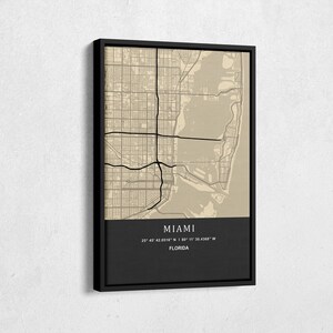 May include: A black and white map of Miami, Florida with the city name and coordinates printed at the bottom. The map is framed in a black frame.