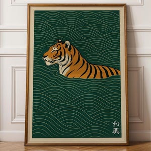 May include: Framed art print featuring a tiger swimming in water. The tiger has orange and black stripes, set against a dark green background with a wave pattern. The print includes Japanese text in the lower right corner.