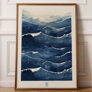 May include: A framed watercolour print showing stylized ocean waves in shades of blue. The artwork features multiple layers of waves, creating a sense of depth and movement. The print is encased in a wooden frame.