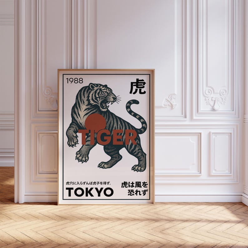 May include: Framed art print featuring a detailed illustration of a tiger with black stripes, a red circle, and the word "TIGER". The print includes Japanese text and the word "TOKYO". The artwork is displayed in a room with white walls and a wooden floor.