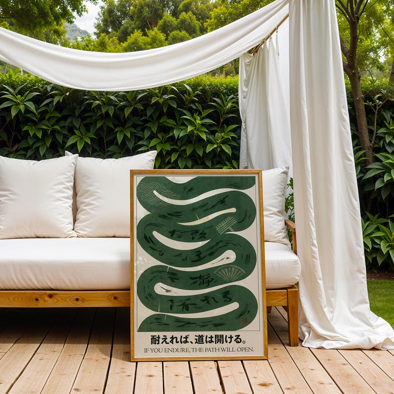 May include: A framed art print featuring a stylized green snake design with Japanese text and the English phrase "IF YOU ENDURE, THE PATH WILL OPEN." The artwork has a cream-colored background and a wooden frame, displayed outdoors.