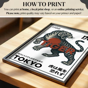 May include: Framed art print featuring a stylized tiger illustration in black and gray with the word "TIGER" in red. The print includes Japanese text and the word "TOKYO". The frame is black.