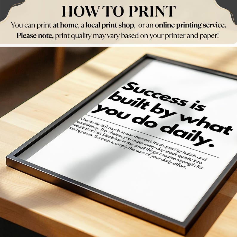 May include: A framed print with the text "Success is built by what you do daily." The print also includes the text "Greatness isn't made in one moment, it's shaped by habits and consistency." The frame is black.