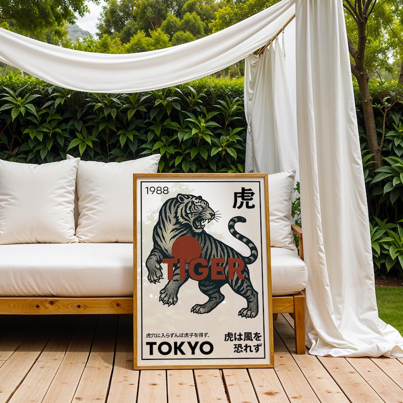 May include: A framed poster featuring a black and gray tiger illustration with the word "TIGER" in red. The poster includes Japanese text and the year "1988". The artwork is displayed outdoors, leaning against a white couch.