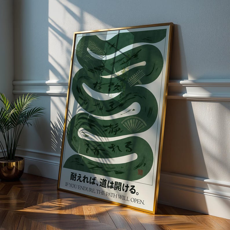 May include: A framed art print featuring a green, stylized snake design with Japanese characters and the English text "IF YOU ENDURE, THE PATH WILL OPEN." The artwork has a gold frame and is leaning against a white wall.