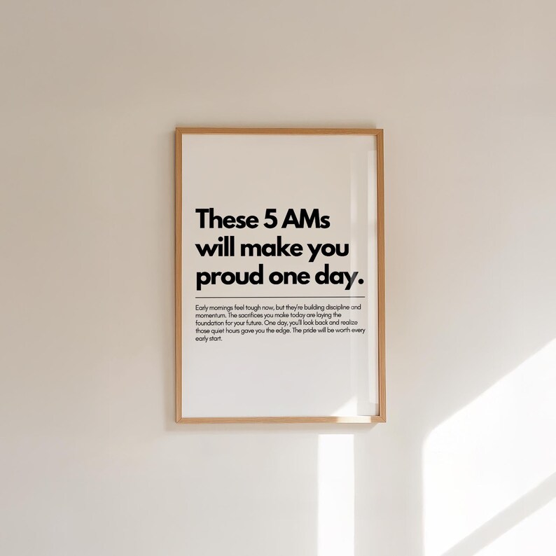 Pu&ograve; includere: Stampa incorniciata con il testo "These 5 AMs will make you proud one day." La stampa ha uno sfondo bianco con testo nero e una cornice in legno. Il testo include un messaggio motivazionale.