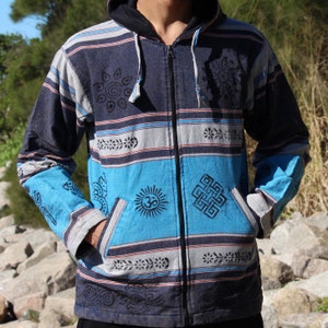 May include: A blue, gray, and turquoise zip-up hoodie with a hood and pockets. The jacket features a striped pattern with various black graphic designs, including sun and floral motifs. The sleeves are turquoise with black patterns.